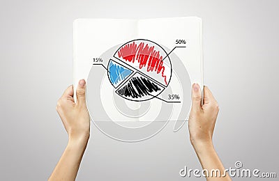 Hands holding a notebook with pie chart graph