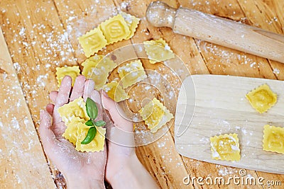 Hands holding ravioli pasta