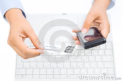 Hands holding smart phone and business card with qr code