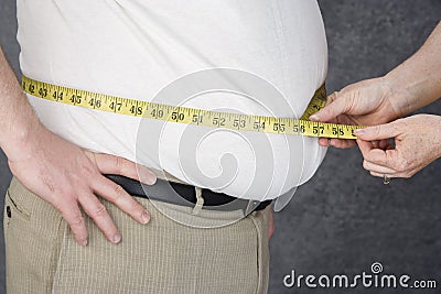 Hands Measuring Abdomen Of Obese Man