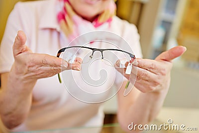 Hands of optician offering glasses