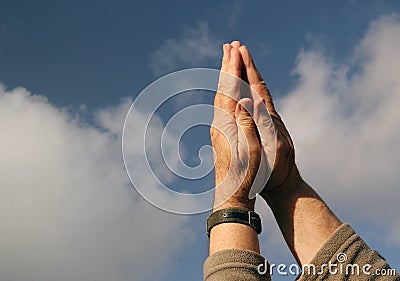Hands praying to heaven. Sky background.