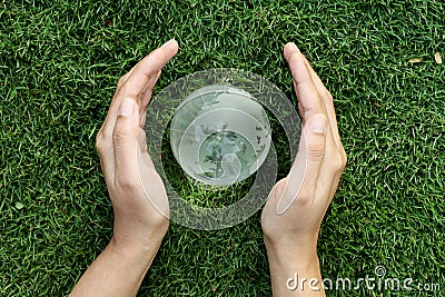 Hands protecting a glass globe