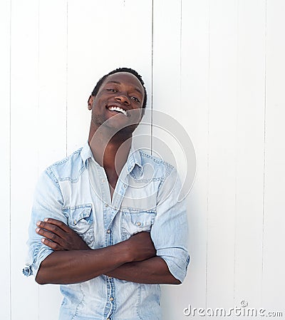 Handsome black man with arms crossed, leaning against white background