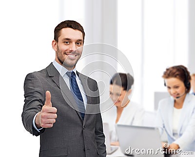 Handsome buisnessman showing thumbs up in office