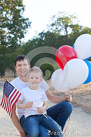Handsome father holding colorful balloons and his little son hol