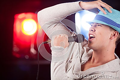 Handsome guy holding mic and singing.