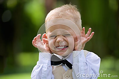 Handsome little boy in a suit to laugh outdoor