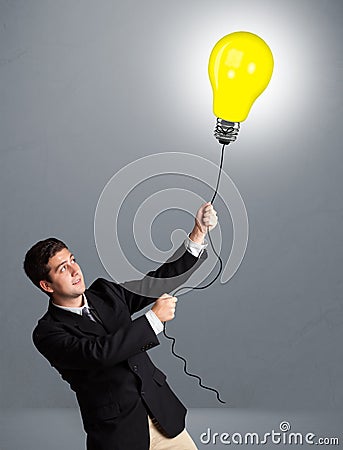Handsome man holding light bulb balloon