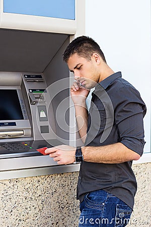 Handsome man looking at a credit card