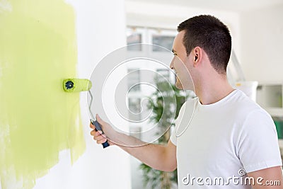 Handsome man painting wall