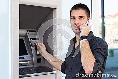 Handsome man on the phone at ATM