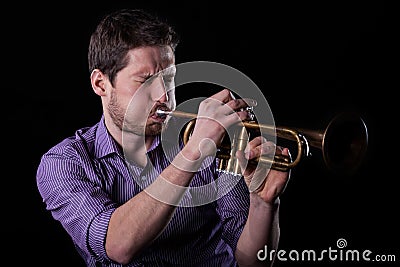 Handsome man playing on trumpet