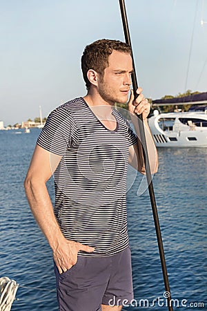 Handsome man standing on a sailing boat - sailing trip.