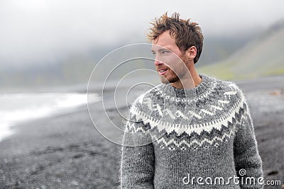 Handsome man walking on Icelandic black sand beach