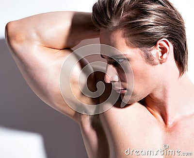 Handsome muscular young man looking sideways.