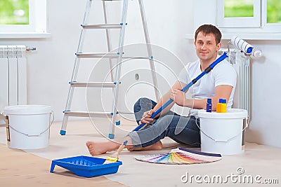 A handsome painter sitting on floor