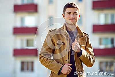 Handsome smiling young man outside an apartment