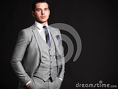 Handsome young business man standing on black