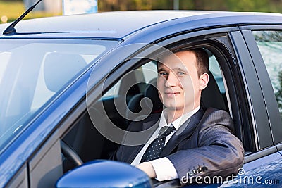 Handsome young businessman in his new car