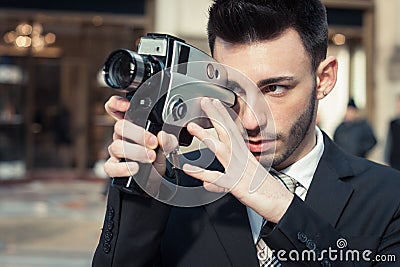 Handsome young businessman using a vintage film camera