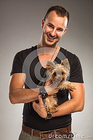 Handsome young man holding a yorkshire terrier dog