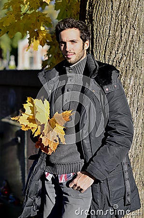 A handsome young man with yellow leaves