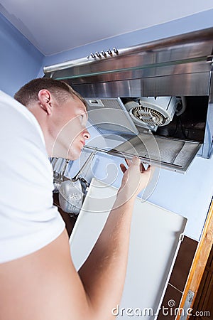 Handyman repairing kitchen extractor fan