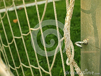 Hang bended soccer nets, white soccer football net. Grass on football playground in the background. Stainless frame.