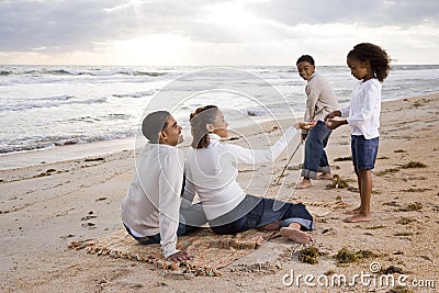 Happy African-American family playing on beach