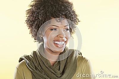 Happy African American woman with a stole round her neck looking away over colored background