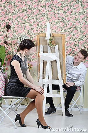 Happy artist peeks out from behind his easel on pretty woman