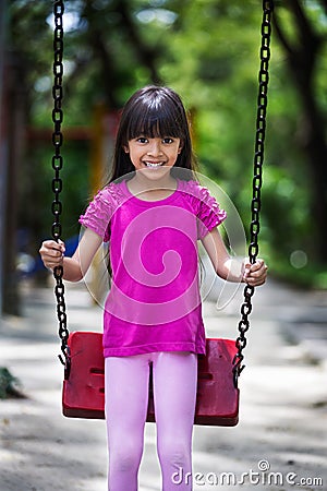 Happy asian little girl smiling on swing