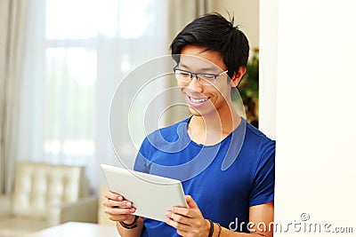 Happy asian man using tablet computer