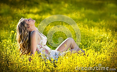 Happy and attractive teen girl in canola field