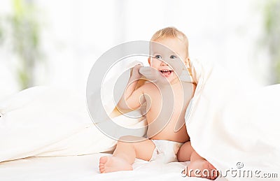 Happy baby under a blanket laughing