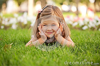 Happy beautiful little girl on the grass