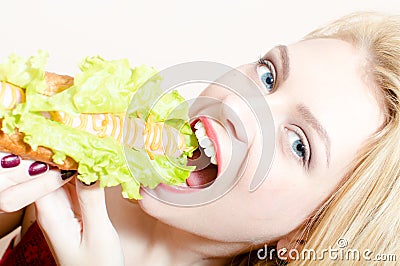 Happy blond woman blue eyes beautiful girl looking at camera having fun eating tasty hot-dog cute smiling on white background