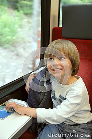 Happy boy with backpack on train