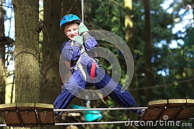 Happy boy climbing in adventure park