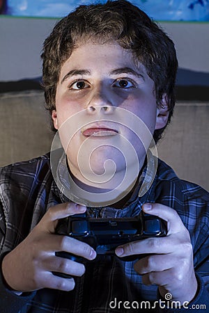 Happy. boy with joystick playing computer game at home.