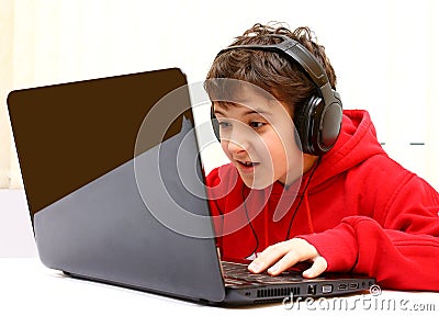 Happy boy playing a game on laptop - computer