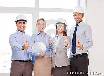 Happy business team in office showing thumbs up