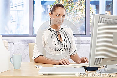 Happy businesswoman busy working on computer