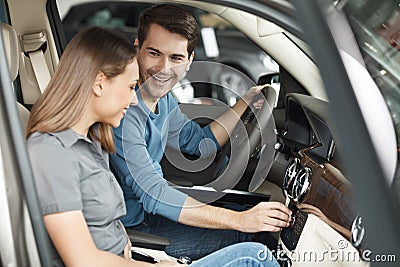 Happy car owners. Beautiful young couple sitting at the front se