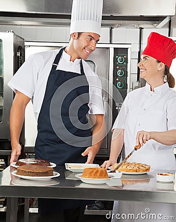 Happy Chefs Preparing Sweet Dishes in Kitchen