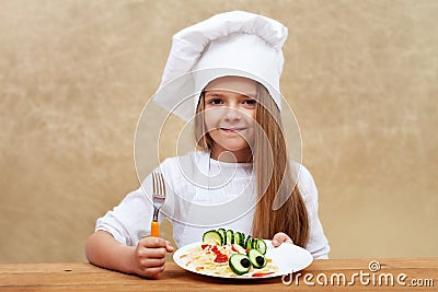 Happy child with chef hat and decorated pasta dish