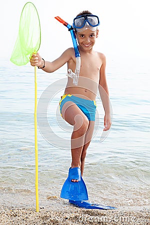 Happy child with diving equipment on the beach