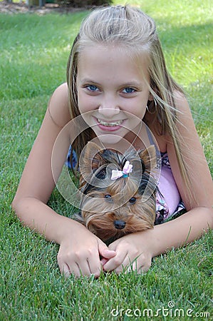 Happy child teen girl smiling with pet puppy