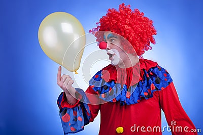 Happy clown with balloon on blue background